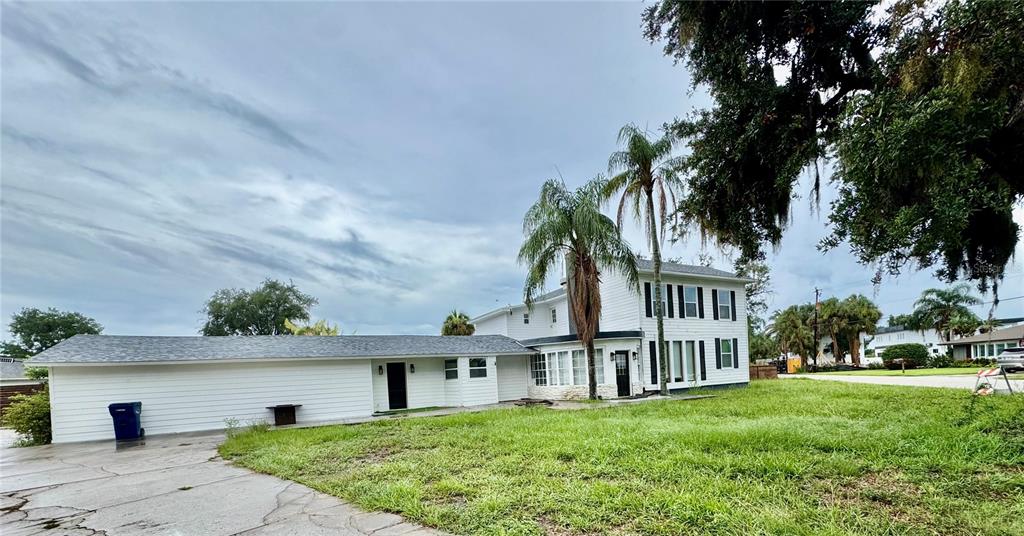 A two-story white house with a long, single-story attached garage and palm trees — 812 TROPICAL DRIVE, BRADENTON, FL