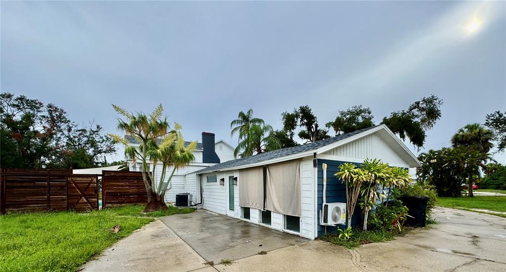 A white and blue exterior of a house with a concrete patio and palm trees — 812 TROPICAL DRIVE, BRADENTON, FL