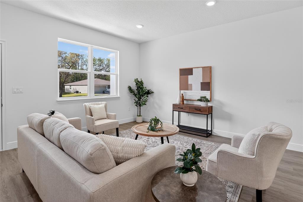 A living room features a beige sofa, two armchairs, a coffee table, and a console table — 99 W GOLDCOAST PLACE, DUNNELLON, FL
