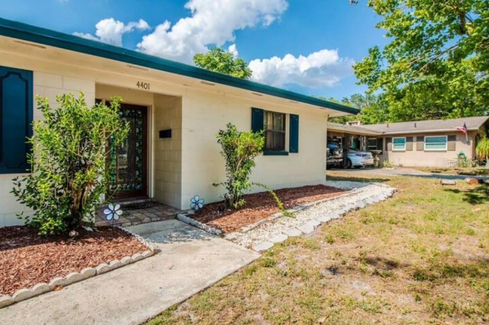 A one-story house with cream-colored exterior walls, blue shutters, and a concrete walkway — 4401 LENMORE STREET UNIT 3, ORLANDO, FL