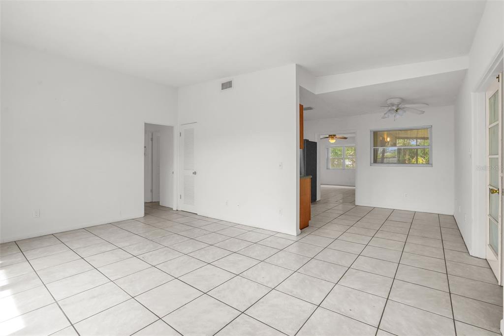 A bright, open-concept living area with white walls and light-colored tile flooring — 417 N TAMPA AVENUE, ORLANDO, FL