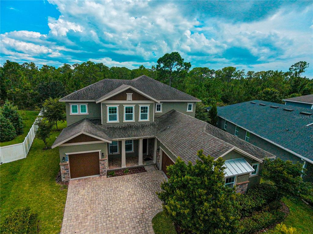 An aerial view of a two-story house with a paved driveway and a green exterior — 9240 BRADLEIGH DRIVE, WINTER GARDEN, FL
