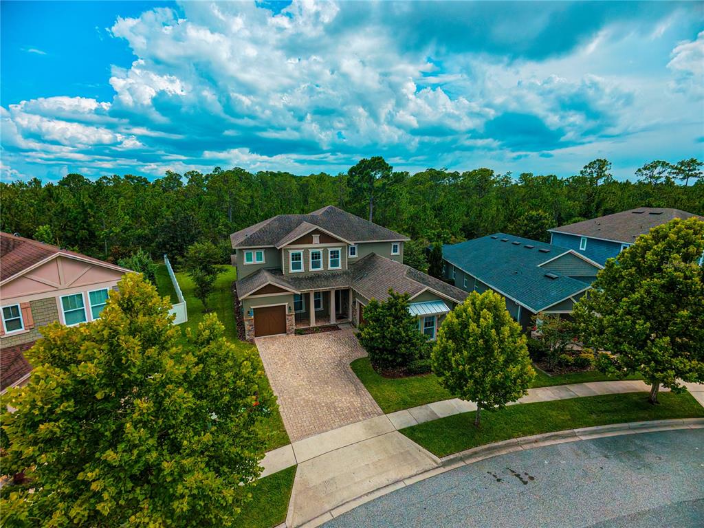 An aerial view of a two-story suburban house with a paved driveway and surrounding trees — 9240 BRADLEIGH DRIVE, WINTER GARDEN, FL