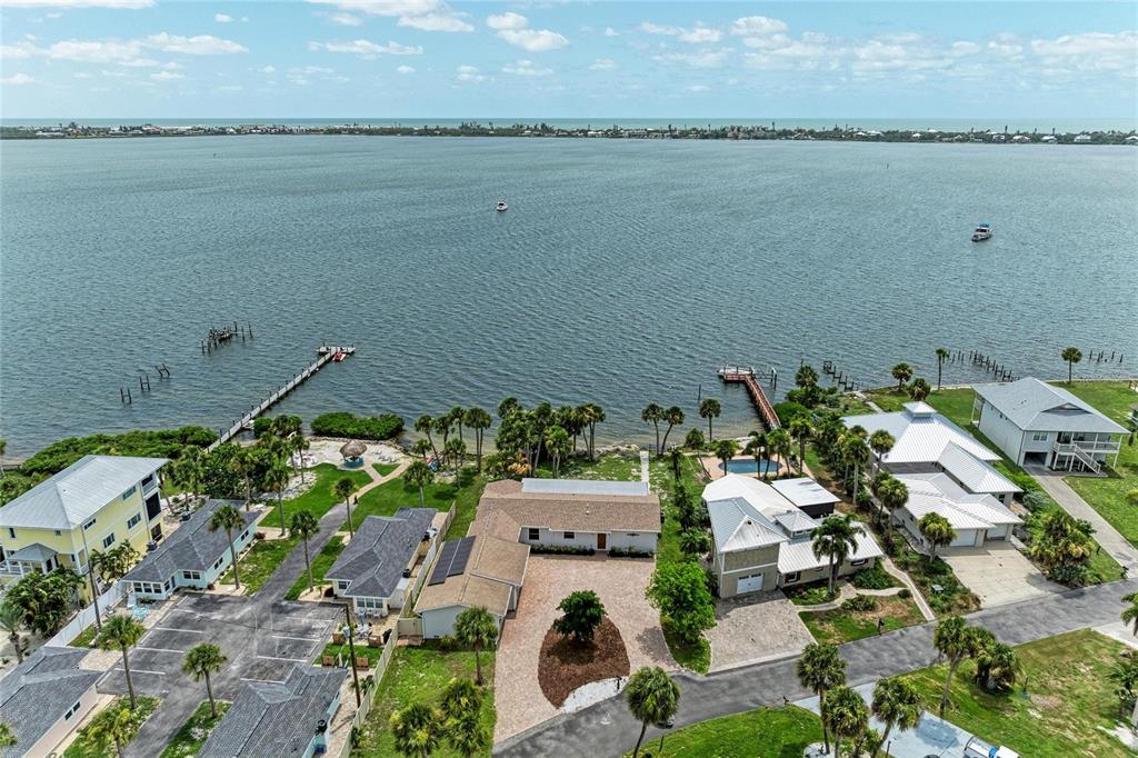 An aerial view shows several waterfront homes with private docks along a large bay — 211 BAHIA VISTA DRIVE, ENGLEWOOD, FL