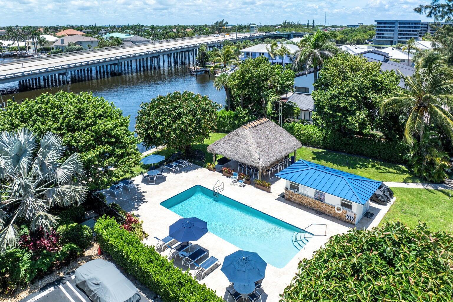 An aerial view of a swimming pool with a tiki hut and a blue-roofed cabana — 1700 S Ocean Boulevard # 4, Delray Beach FL 33483, DELRAY BEACH, FL