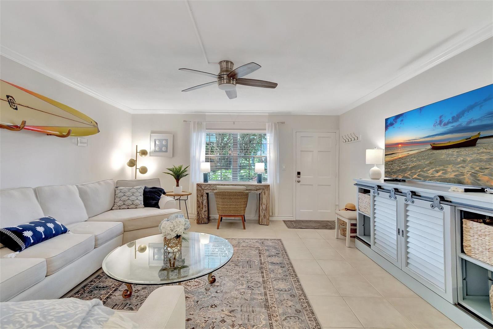 A living room features a white sectional sofa, a glass coffee table, and a television — 1700 S Ocean Boulevard # 4, Delray Beach FL 33483, DELRAY BEACH, FL