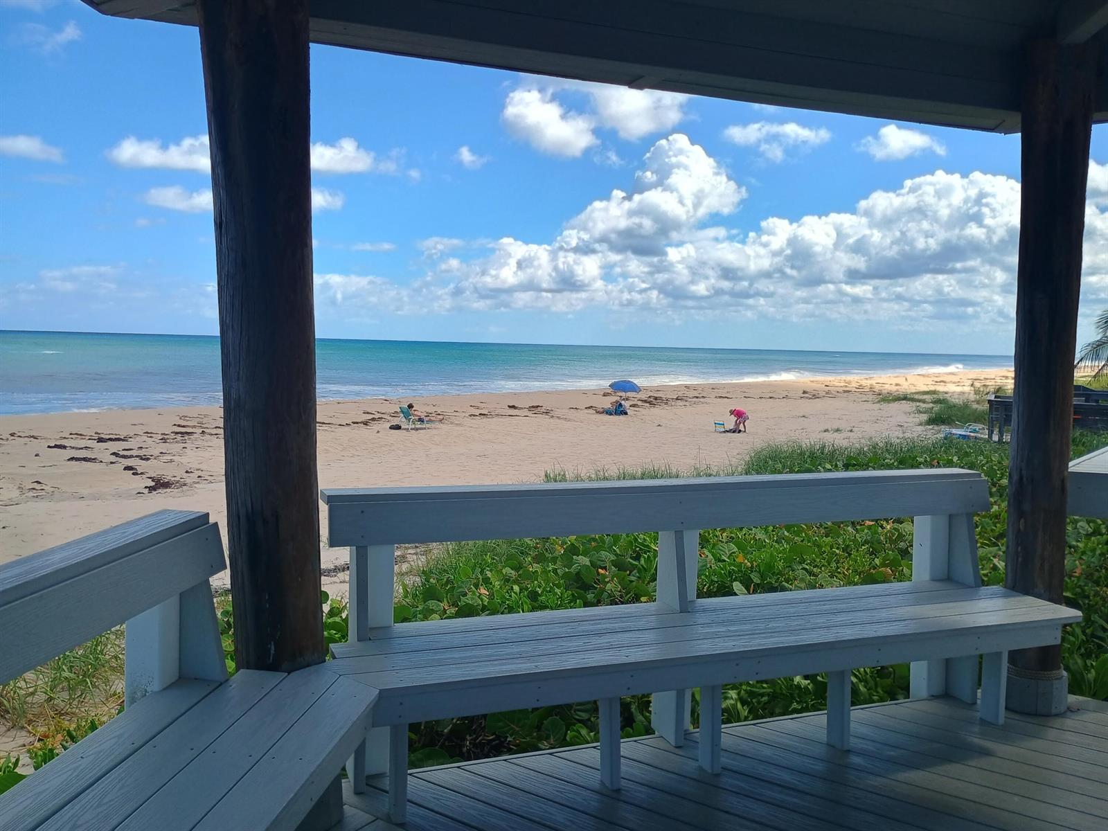A wooden deck with built-in benches overlooks a sandy beach and the ocean — 5505 N Ocean Boulevard # 110, Ocean Ridge FL 33435, OCEAN RIDGE, FL