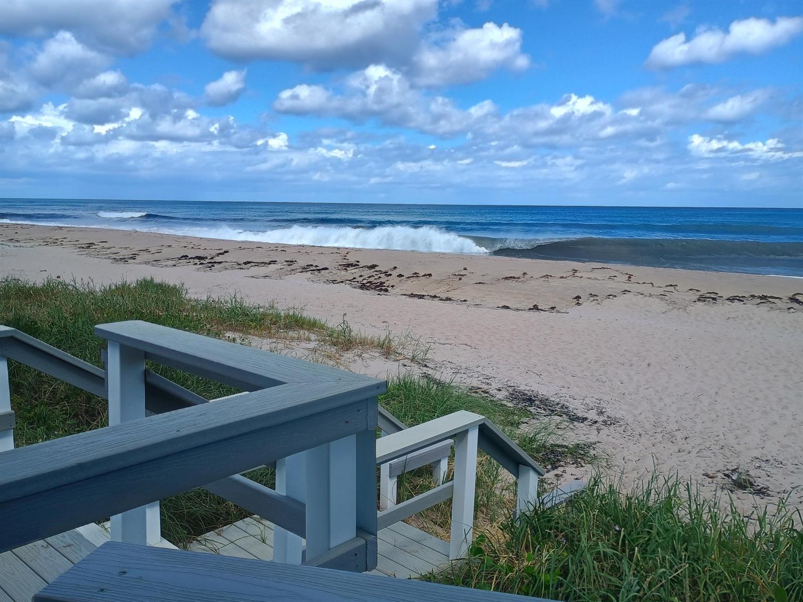 A wooden staircase leads from a deck down to a sandy beach and the ocean — 5505 N Ocean Boulevard # 110, Ocean Ridge FL 33435, OCEAN RIDGE, FL