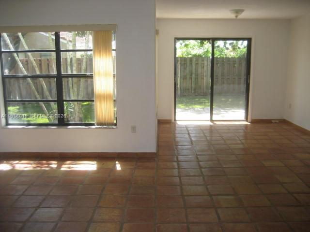 An interior room features terracotta tile flooring, a large window, and sliding glass patio doors — 13224 SW 10 TE # 0, Miami FL 33184, MIAMI, FL