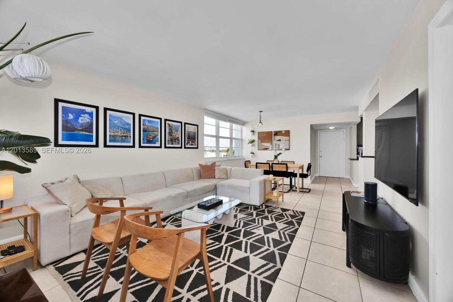 A living room features a sectional sofa, a patterned rug, and a wall-mounted television — 2016 Bay Dr # 604, Miami Beach FL 33141, MIAMI BEACH, FL