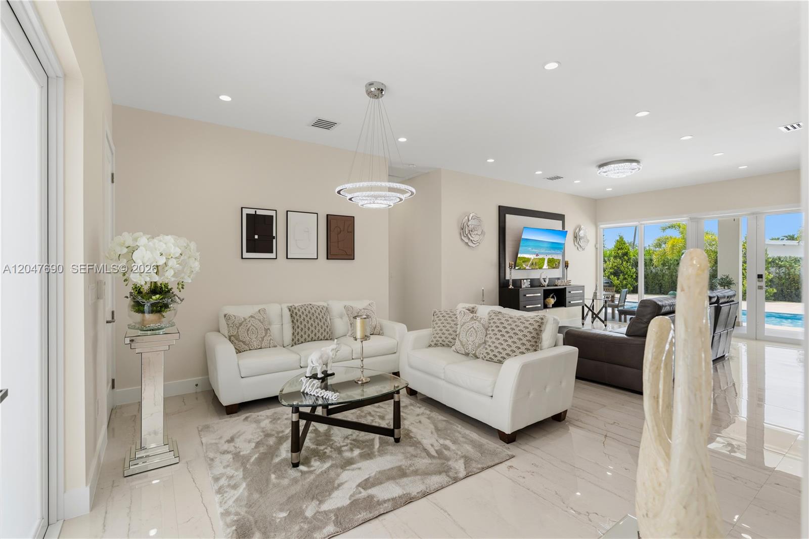 A bright living room features white sofas, a glass coffee table, and tile flooring — 3000 SW 103rd Ave, Miami FL 33165, MIAMI, FL