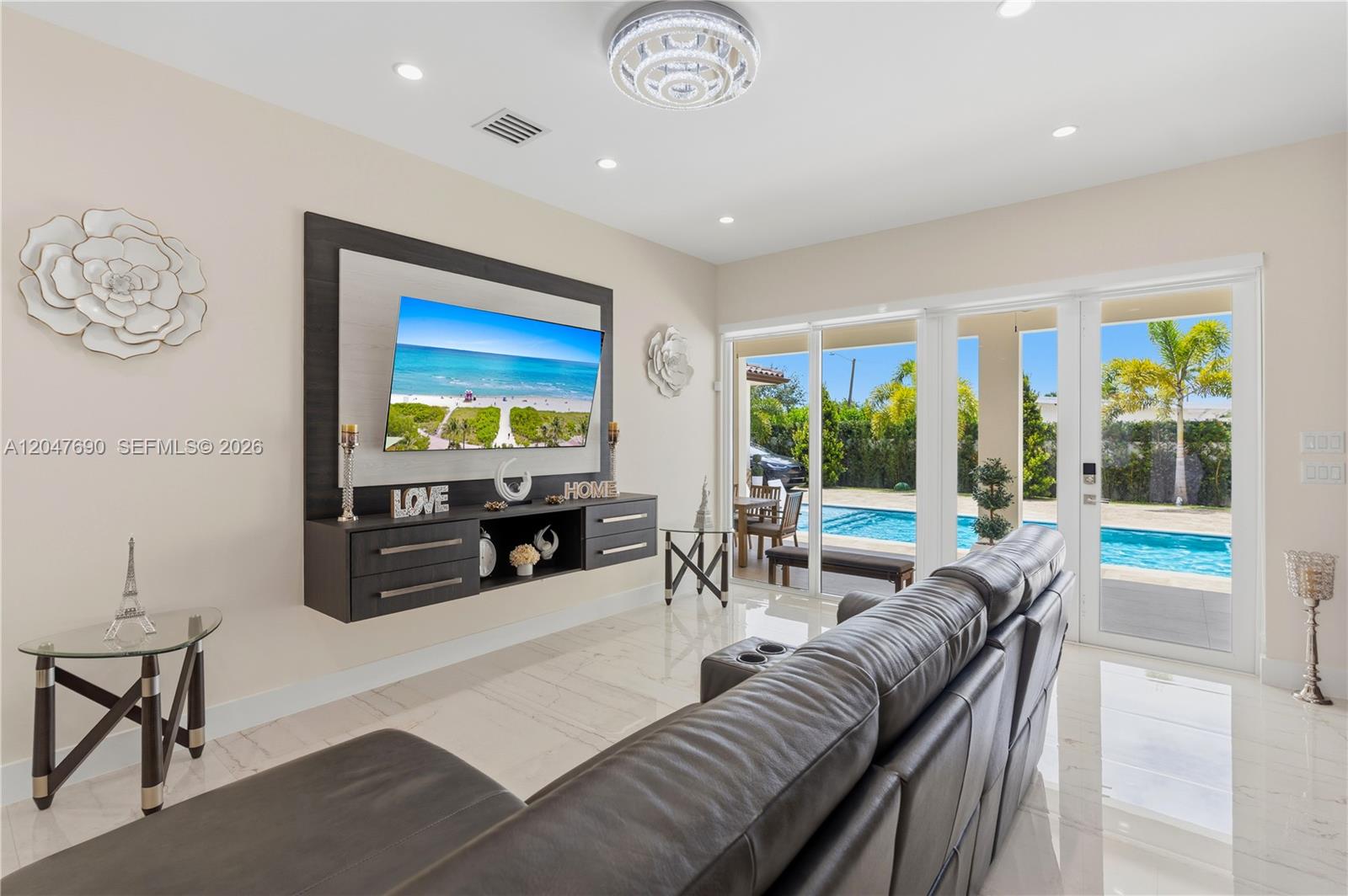 A living room features a wall-mounted television, dark cabinetry, tile flooring, and sliding glass doors — 3000 SW 103rd Ave, Miami FL 33165, MIAMI, FL