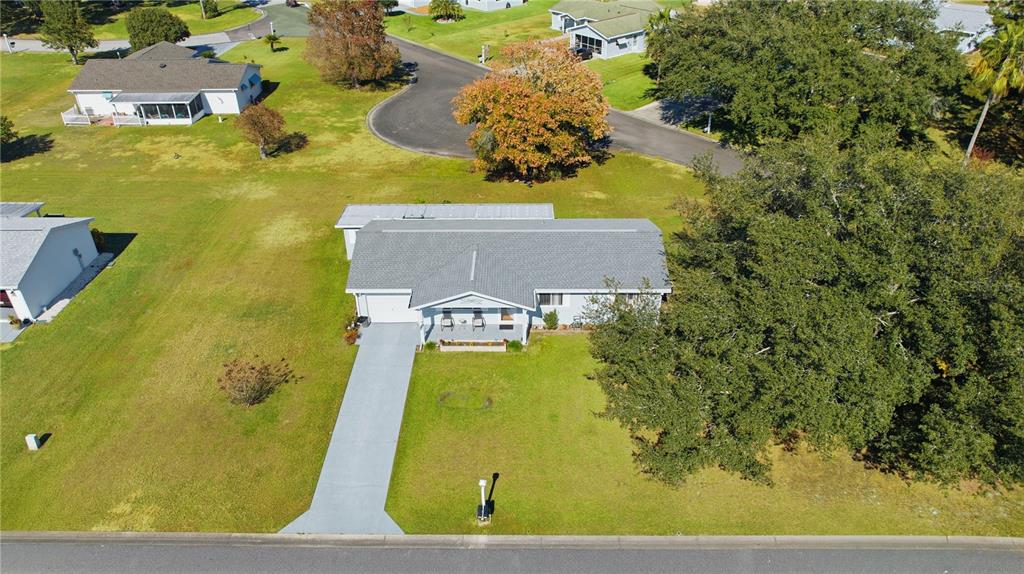 An aerial view shows a single-story house with a gray roof and a concrete driveway — 10599 SE 178TH STREET, SUMMERFIELD, FL