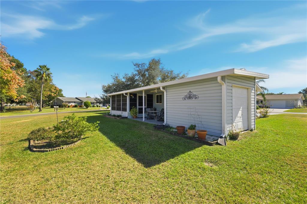 A light blue mobile home with a screened-in porch and a small attached storage shed — 10599 SE 178TH STREET, SUMMERFIELD, FL