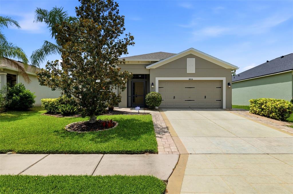 A single-story house with a beige exterior, a two-car garage, and a front lawn — 8854 39TH STREET CIRCLE E, PARRISH, FL