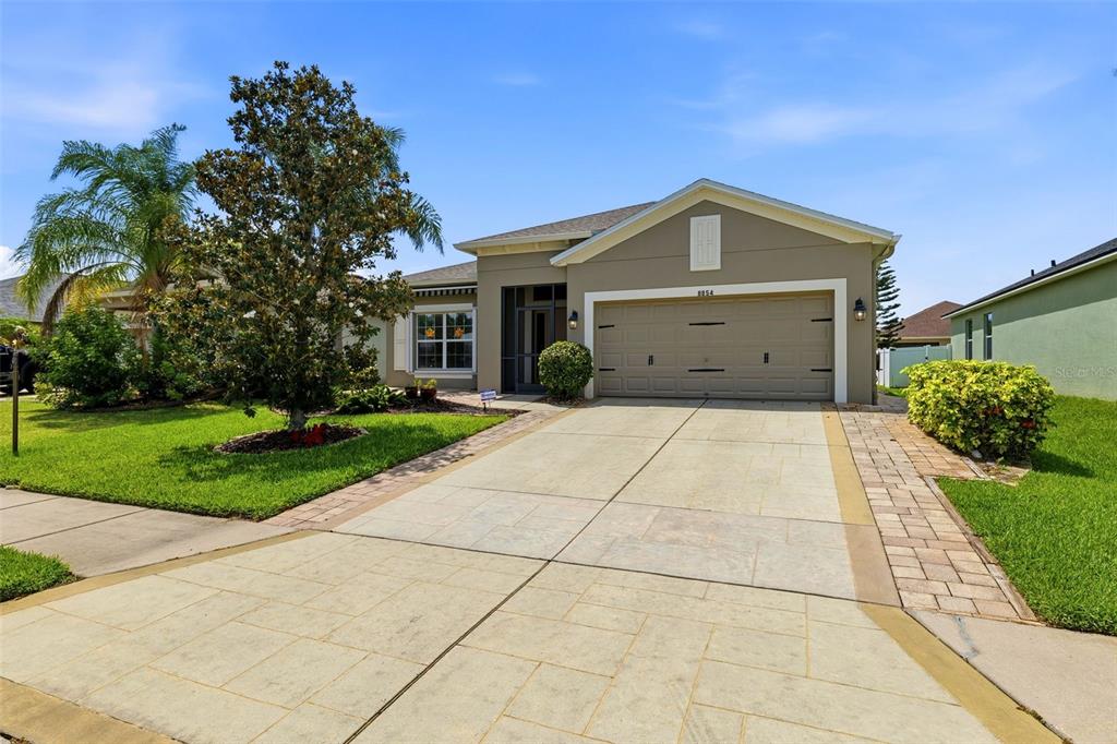 A single-story house with a beige stucco exterior, a two-car garage, and a paved driveway — 8854 39TH STREET CIRCLE E, PARRISH, FL