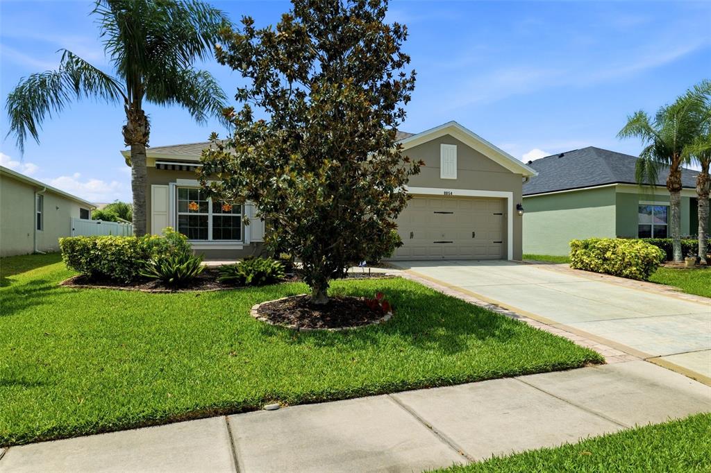 A single-story house with a beige exterior, a two-car garage, and a front yard — 8854 39TH STREET CIRCLE E, PARRISH, FL