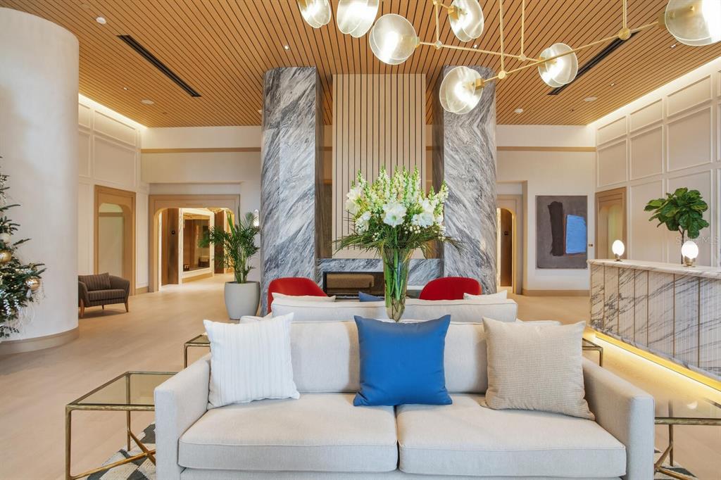 A modern lobby features a marble fireplace, a central sofa, and a slatted wood ceiling — 3015 S YSABELLA AVENUE UNIT 1202, TAMPA, FL