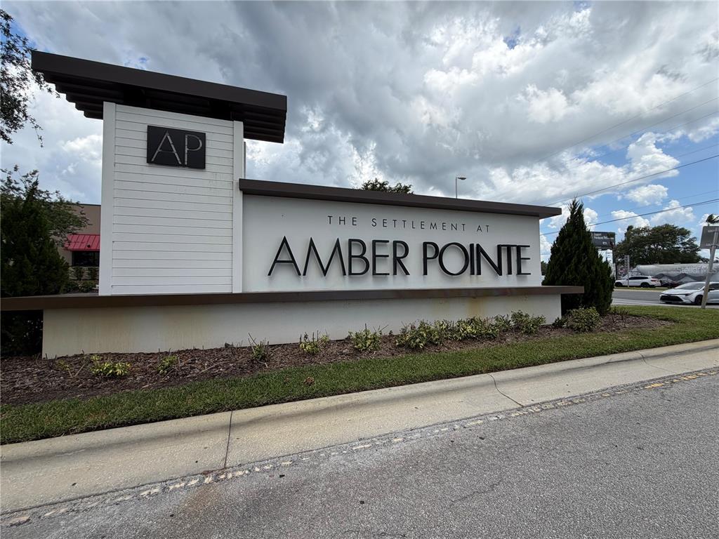 A modern monument sign displays the name The Settlement at Amber Pointe — 2573 AVENTURINE STREET, KISSIMMEE, FL