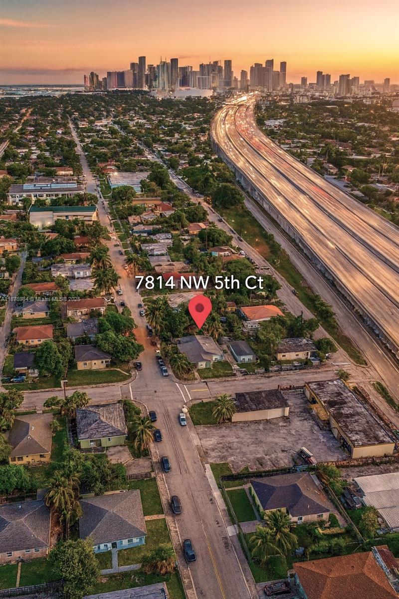 An aerial view shows a residential neighborhood with a highway and city skyline nearby — 7814 NW 5th Ct, Miami FL 33150, MIAMI, FL