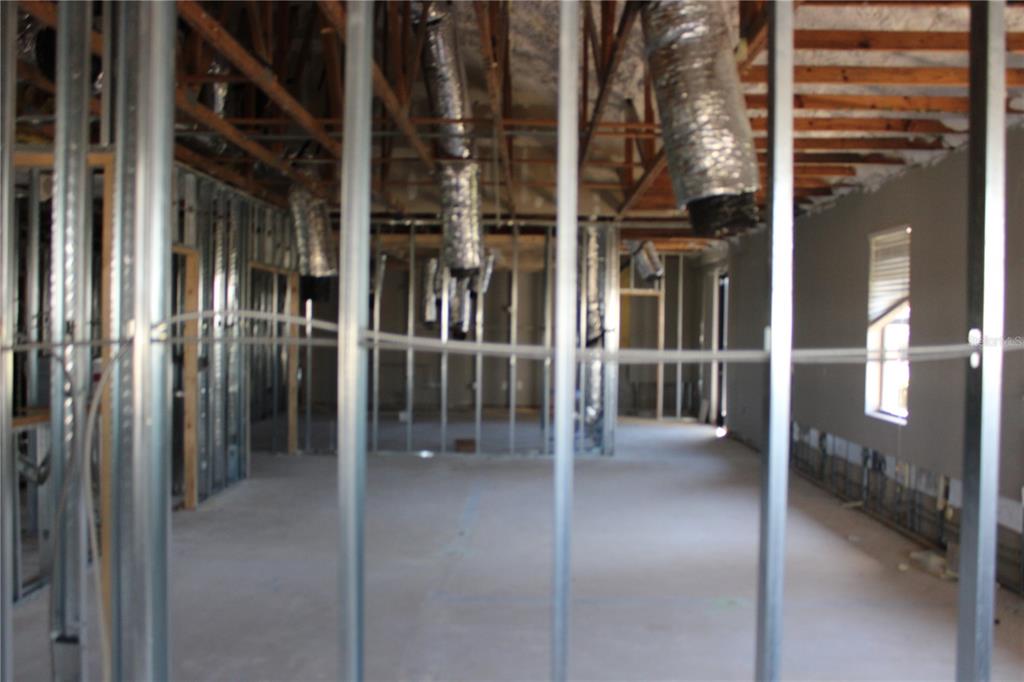 An interior view of a room under construction featuring metal wall studs and exposed ductwork — 8820 BELAGIO DRIVE, NEW PORT RICHEY, FL