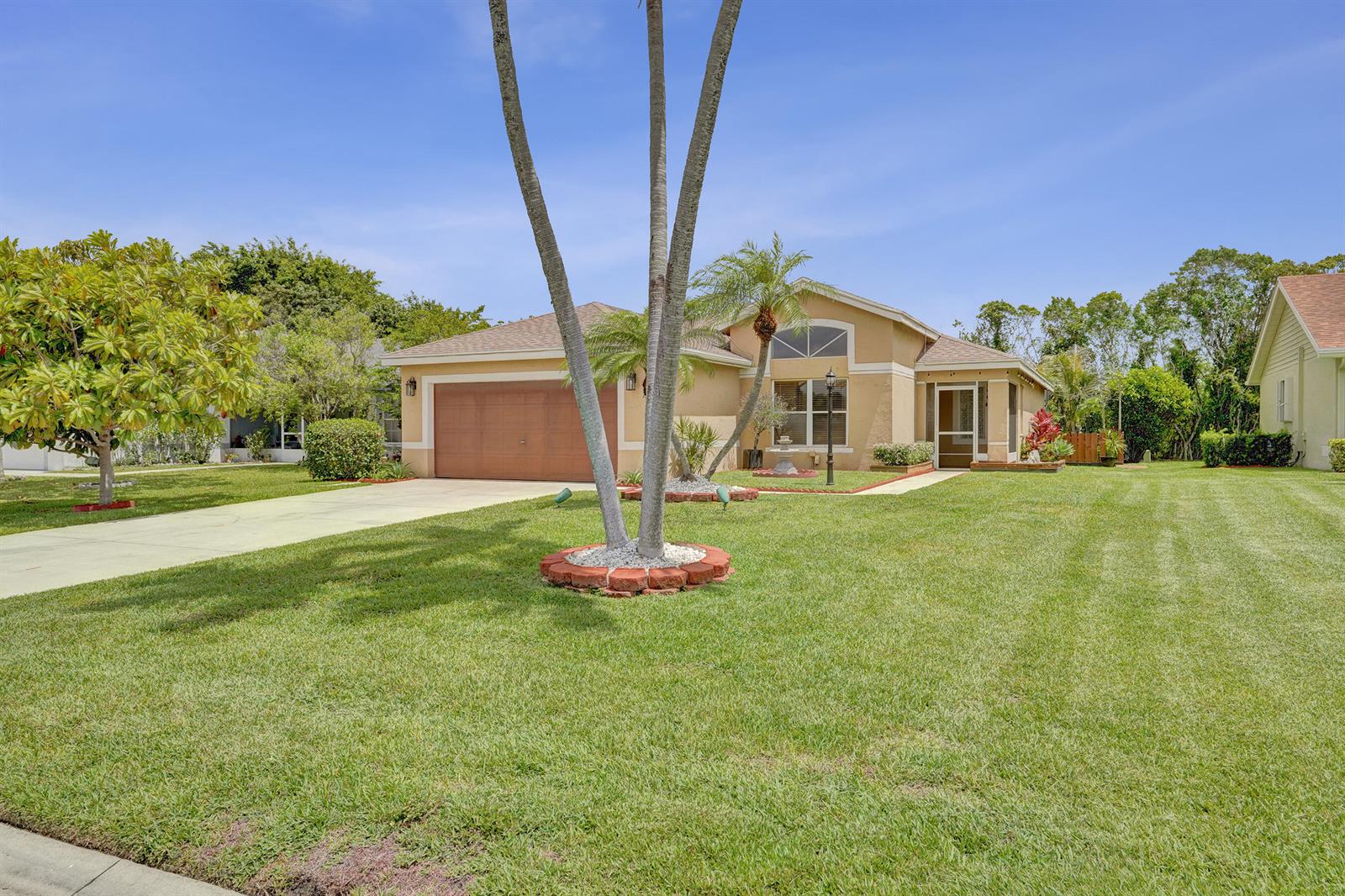 A single-story tan house with a two-car garage and a large front lawn — 6817 Barnwell Drive, Boynton Beach FL 33437, BOYNTON BEACH, FL