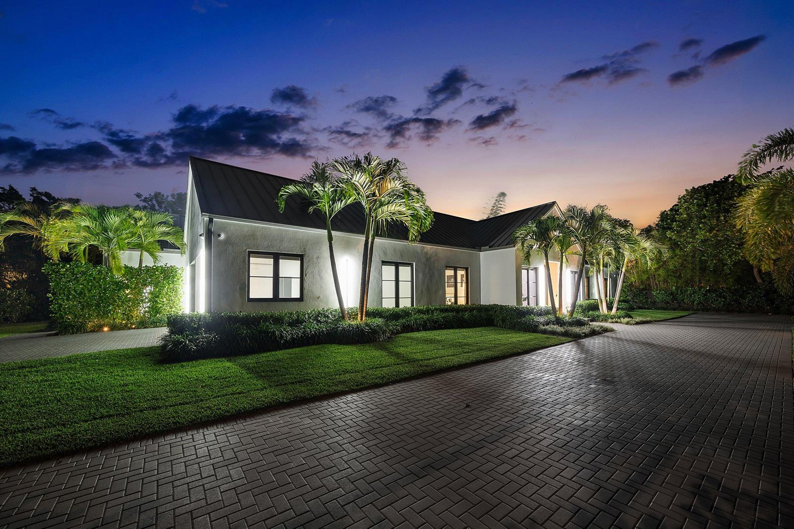 A single-story house with a dark metal roof and palm trees at twilight — 1275 N Swinton Avenue, Delray Beach FL 33444, DELRAY BEACH, FL