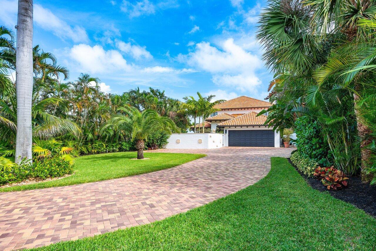 A paved driveway leads to a two-story house with a tile roof and garage — 1 S 18th Avenue S, FL 33460, FL