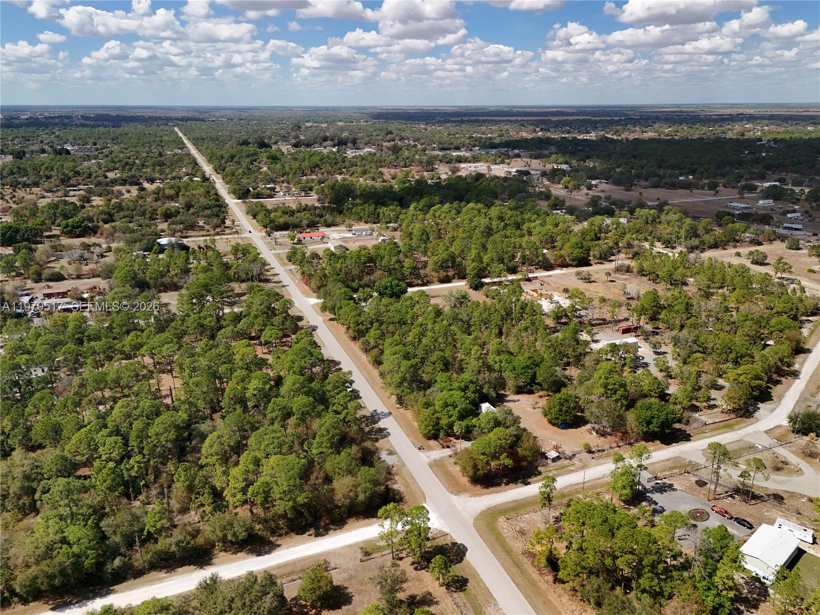 An aerial view shows a rural road intersecting with a dirt path amidst wooded land — 439 AVENIDA DEL SUR, Clewiston FL 33440, CLEWISTON, FL
