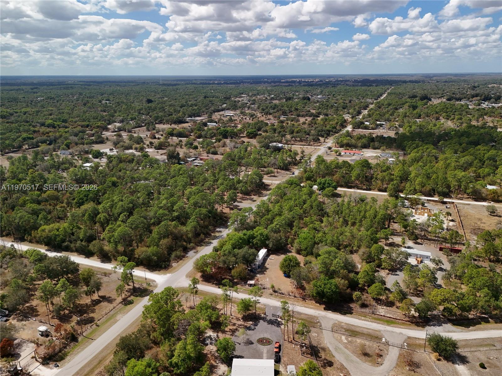 An aerial view shows a rural landscape with scattered houses, dirt roads, and dense trees — 439 AVENIDA DEL SUR, Clewiston FL 33440, CLEWISTON, FL