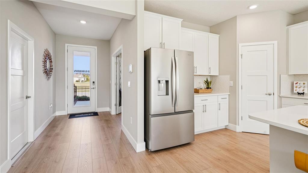 A kitchen with white cabinets, stainless steel appliances, and light wood flooring — 4217 SW 52ND LANE ROAD, OCALA, FL