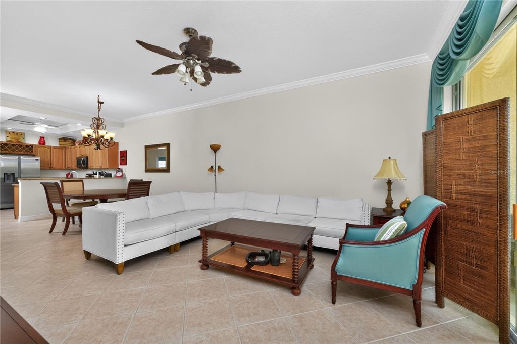 A living room with a white sectional sofa, a coffee table, and a blue armchair — 3228 WOOD THRUSH DRIVE UNIT 112, PUNTA GORDA, FL
