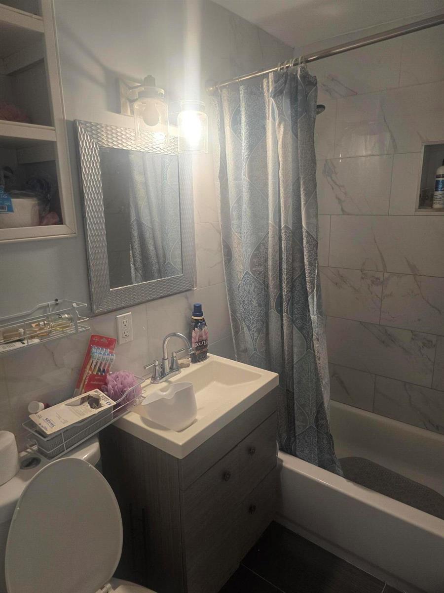 A bathroom features a vanity with a sink, a mirror, and a shower-tub combination — 3016 E Palm Drive, Boynton Beach FL 33435, BOYNTON BEACH, FL