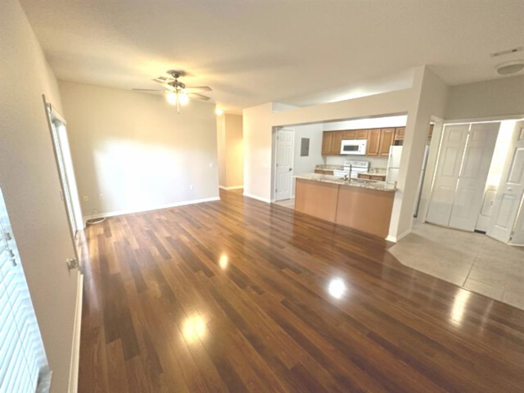 An open-concept living area features dark wood flooring, a ceiling fan, and a kitchen island — 903 EAGLE POND DRIVE UNIT 903, WINTER HAVEN, FL