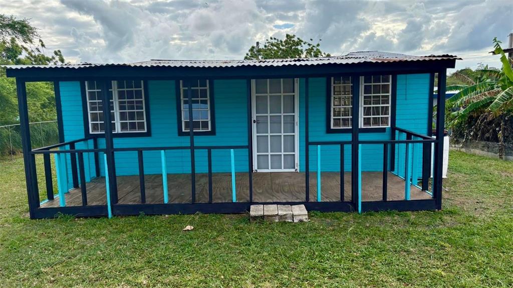 A bright blue wooden cabin with a front porch and a corrugated metal roof — Sola 10 BO LLANOS COSTA, BOQUERON, PR
