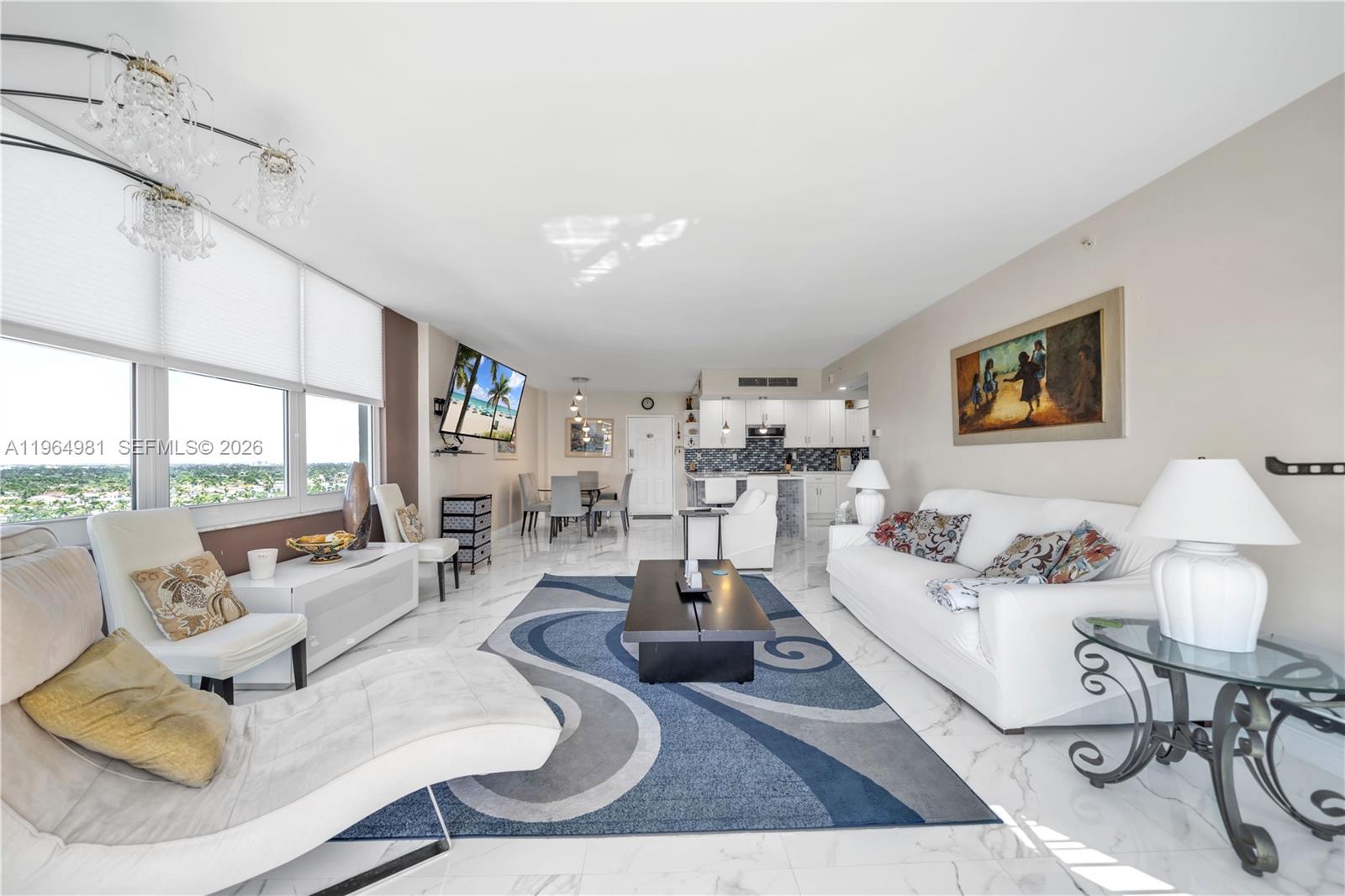 A bright, open-concept living and dining area features white marble floors and a blue rug — 2501 S Ocean Dr, Hollywood FL 33019, HOLLYWOOD, FL