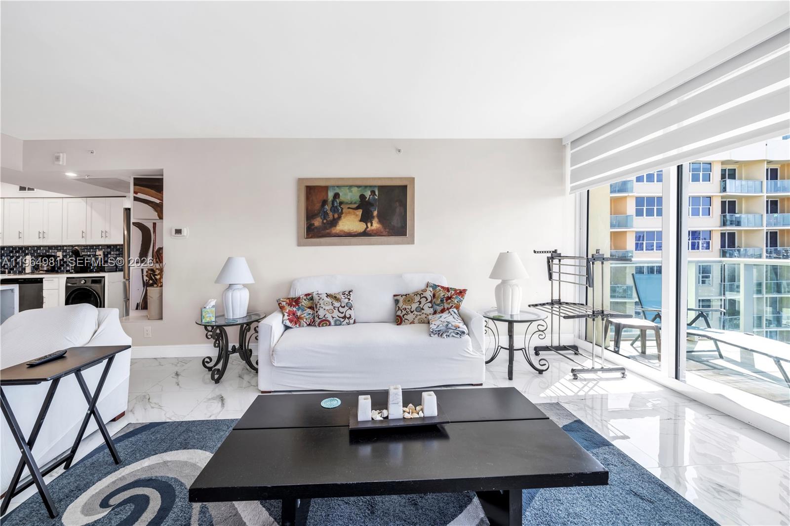 A living room features a white sofa, a black coffee table, and a balcony view — 2501 S Ocean Dr, Hollywood FL 33019, HOLLYWOOD, FL