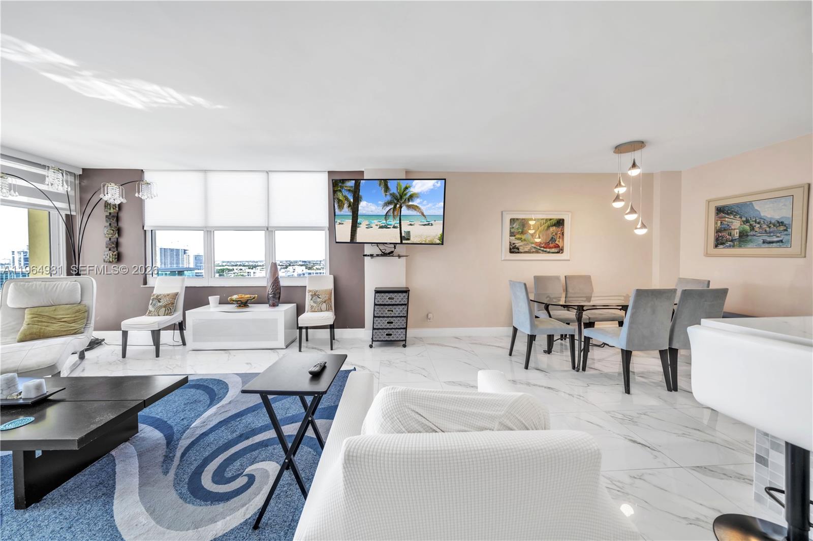 A living and dining area features white marble floors, a blue rug, and large windows — 2501 S Ocean Dr, Hollywood FL 33019, HOLLYWOOD, FL