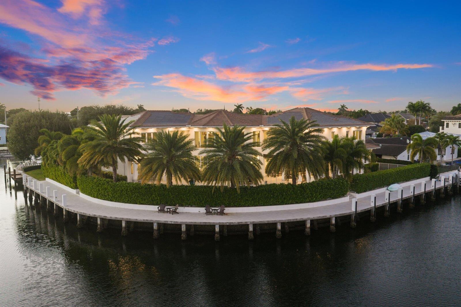 An aerial view of a large waterfront mansion with palm trees and a curved dock — 3700 NE 24th Avenue, Lighthouse Point FL 33064, LIGHTHOUSE POINT, FL