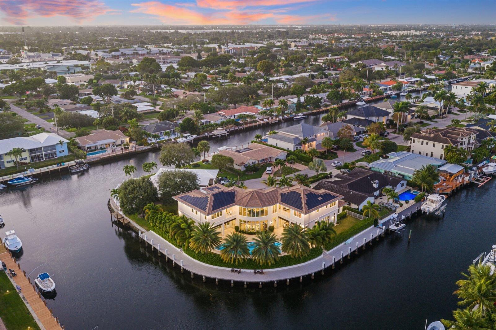 An aerial view of a waterfront mansion with a pool, dock, and solar panels — 3700 NE 24th Avenue, Lighthouse Point FL 33064, LIGHTHOUSE POINT, FL