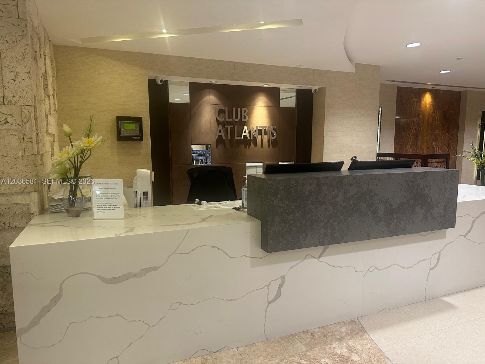 A modern reception desk with white marble-patterned surfaces and a dark gray accent panel — 2555 Collins Ave # 2204, Miami Beach FL 33140, MIAMI BEACH, FL