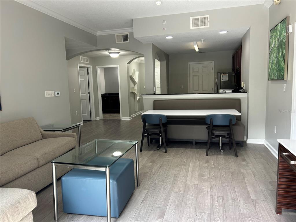 A living room and dining area feature gray walls, wood-look flooring, and a breakfast nook — 14501 GROVE RESORT AVENUE UNIT 1409, WINTER GARDEN, FL