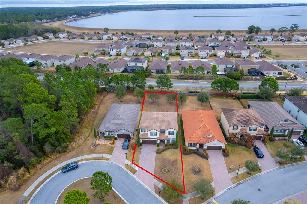 An aerial view shows a residential street with a highlighted single-family home and backyard — 163 ANCONA AVENUE, DEBARY, FL