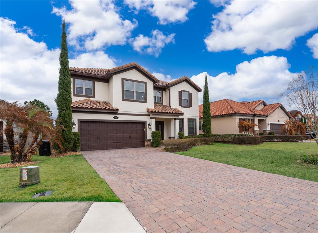A two-story house with a brown garage, tile roof, and a paved driveway — 163 ANCONA AVENUE, DEBARY, FL