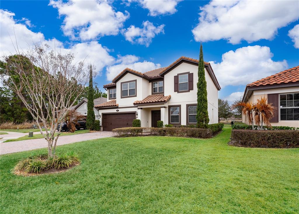 A two-story suburban house with a tiled roof, brown garage, and a green lawn — 163 ANCONA AVENUE, DEBARY, FL
