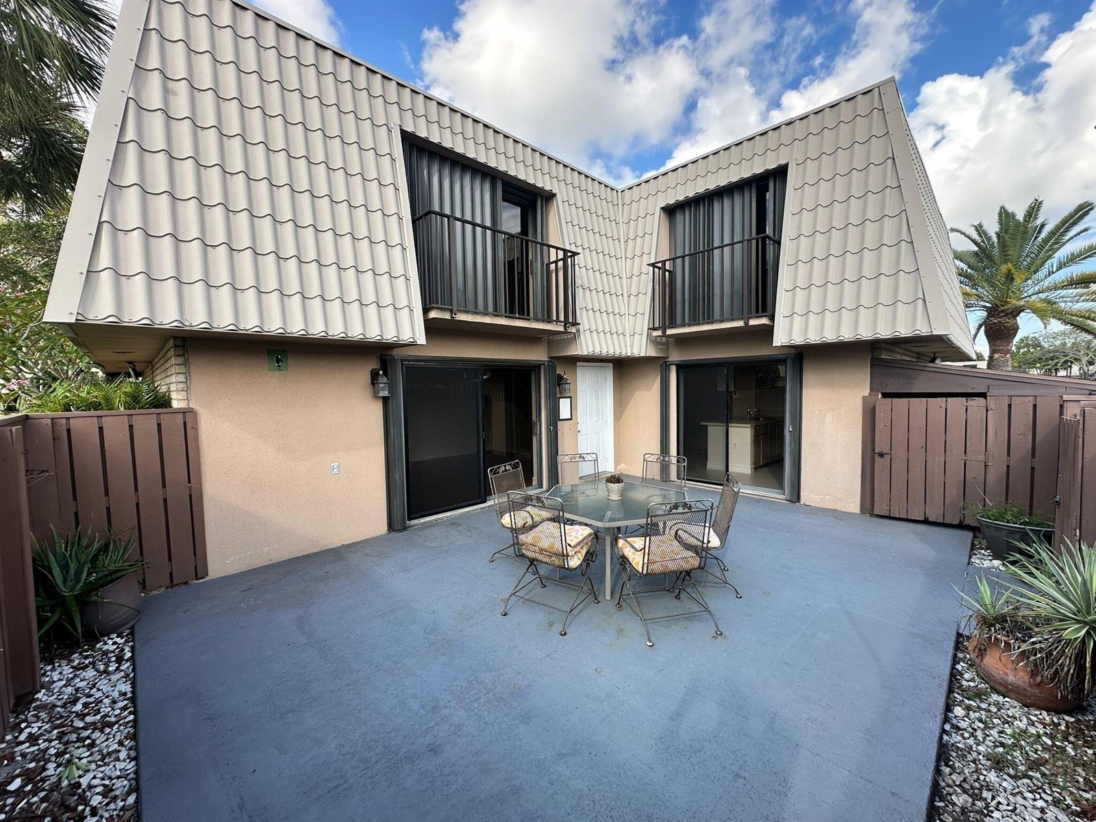 A two-story building with a patio, outdoor dining set, and two upper-level balconies — 5718 57th Way, West Palm Beach FL 33409, WEST PALM BEACH, FL
