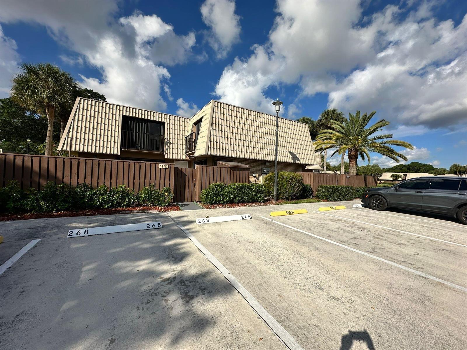 A two-story building with a tiled roof sits behind a parking lot with numbered spaces — 5718 57th Way, West Palm Beach FL 33409, WEST PALM BEACH, FL