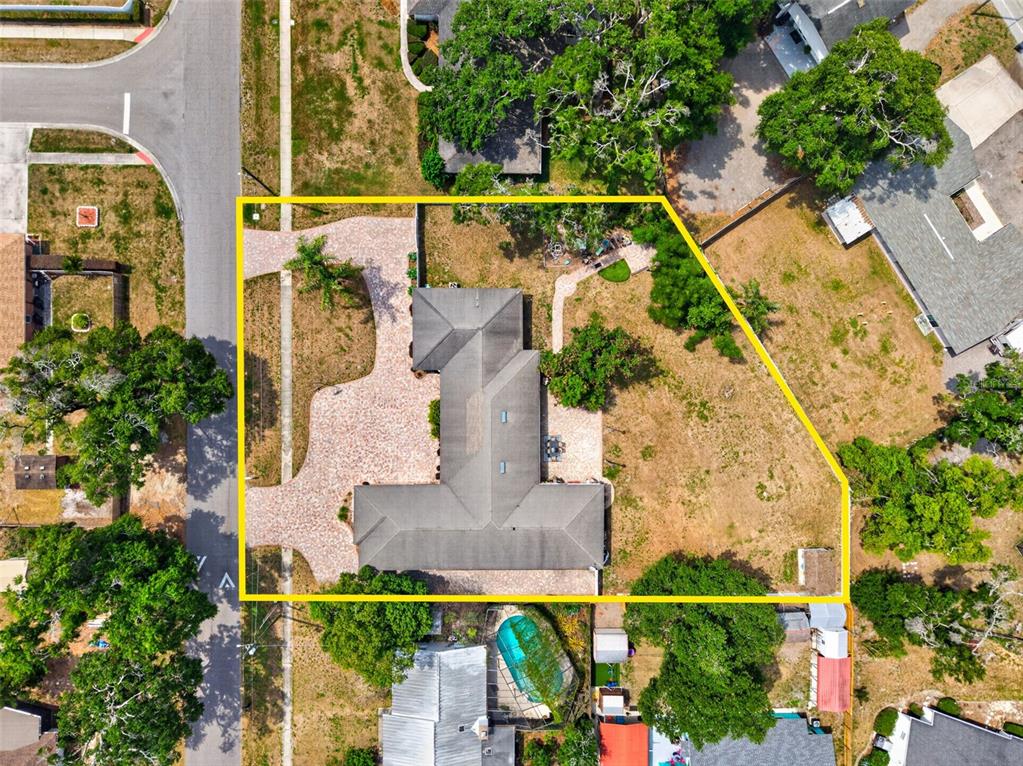 This aerial view shows a house with a paver driveway on a large corner lot — 712 S OAKWOOD AVENUE, BRANDON, FL