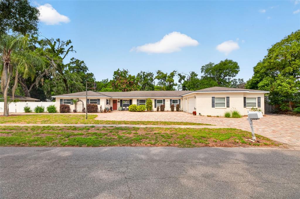 A single-story ranch-style house with a brick driveway and a large front yard — 712 S OAKWOOD AVENUE, BRANDON, FL