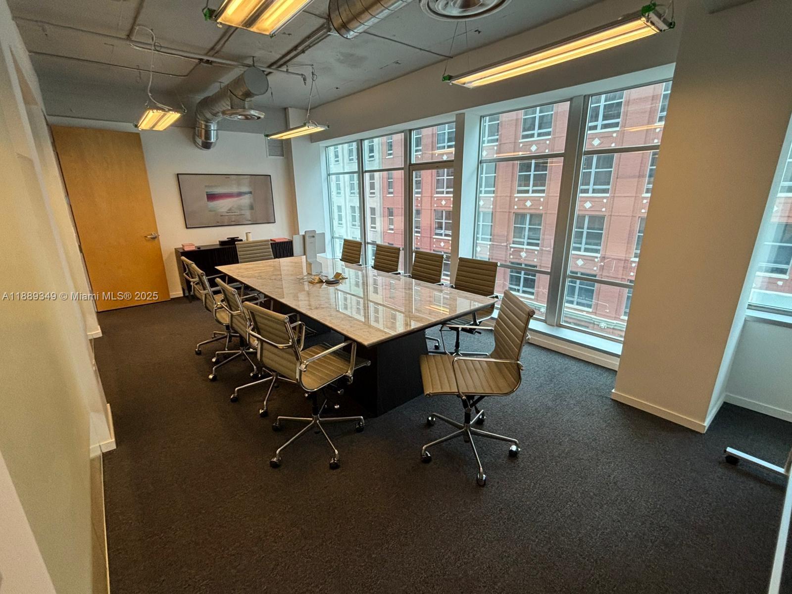 A conference room features a long marble-topped table, rolling chairs, and large windows overlooking buildings — 14 NE 1st Ave, Miami FL 33132, MIAMI, FL